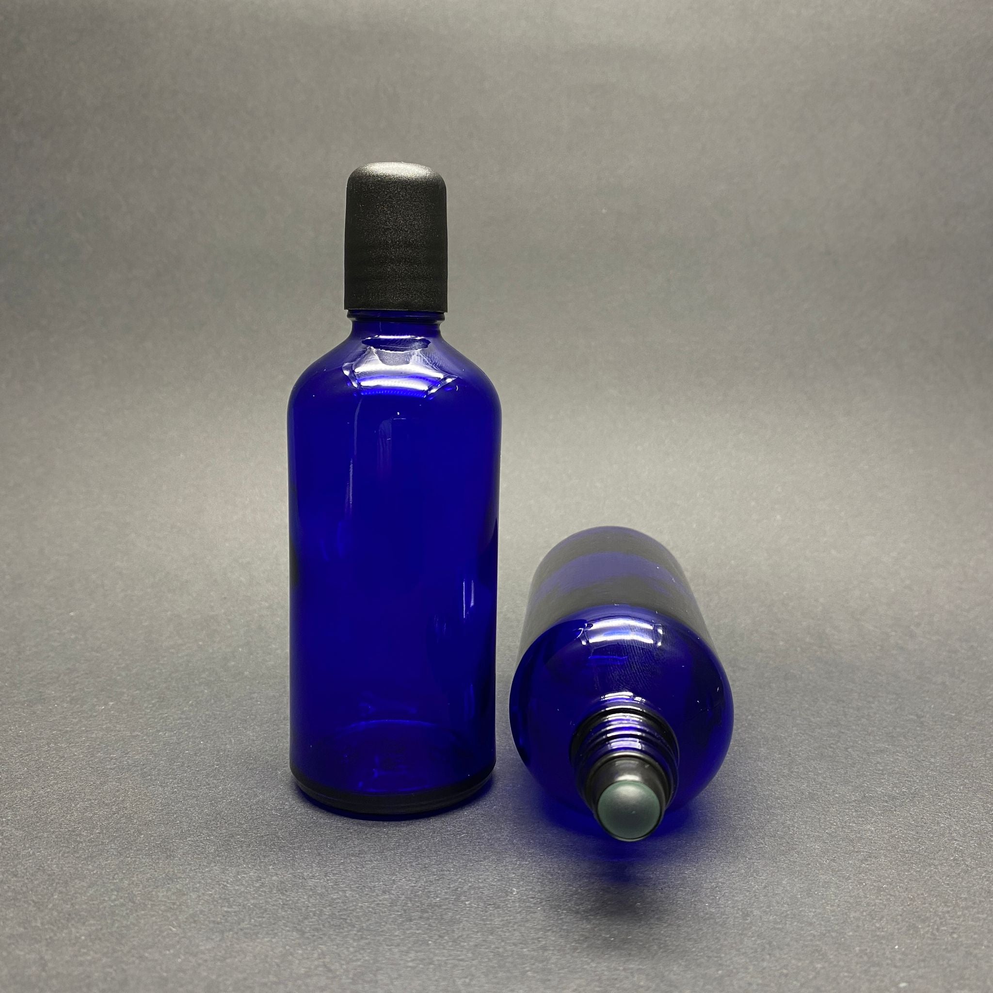 100 CC СИНЯ СТЪКЛЕНА РОЛ-ОН БУТИЛКА - С ЧЕРНА КАПАЧКА - 100 ML СТЪКЛЕНА БУТИЛКА С ТОПЧЕ - СТЪКЛЕНА РОЛ-ОН БУТИЛКА - СТЪКЛЕНА БУТИЛКА С ЕСЕНЦИЯ